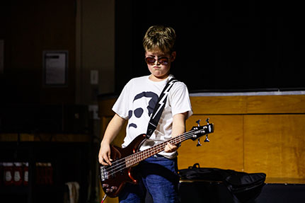 A boy playing a guitar in a talent show. Links to Gifts That Protect Your Assets A boy playing a guitar in a talent show. Links to Gifts That Protect Your Assets