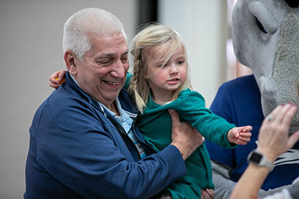 A grandparent holding his grandchild with a smile. Links to Gifts That Pay You Income A grandparent holding his grandchild with a smile. Links to Gifts That Pay You Income