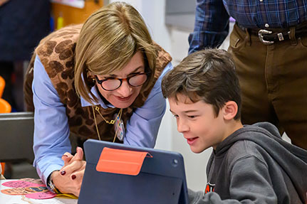 A grandmother helping her grandson on an iPad. Link to Life Stage Gift Planner Ages 60-70 Situations.